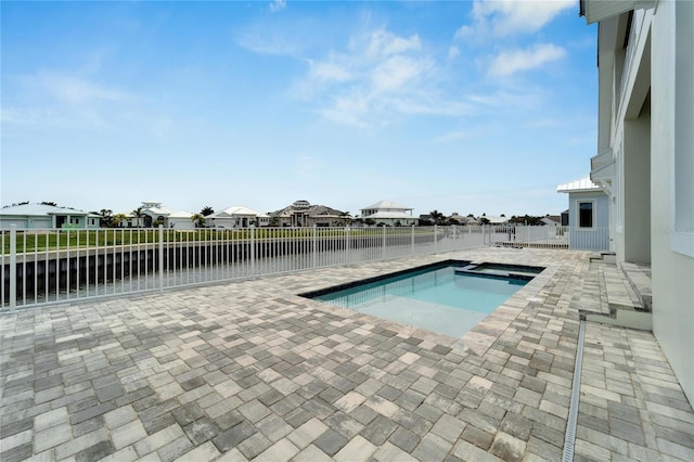 view of swimming pool featuring an in ground hot tub, a water view, and a patio area