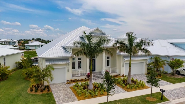 view of front of property with a porch, a garage, and a front lawn