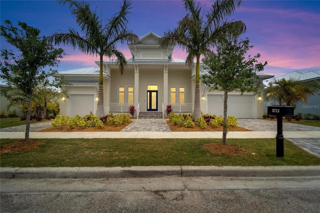 5713 Tybee Island Dr, Apollo Beach, FL 33572 - view of front of property with a porch, driveway, stucco siding, metal roof, and a standing seam roof