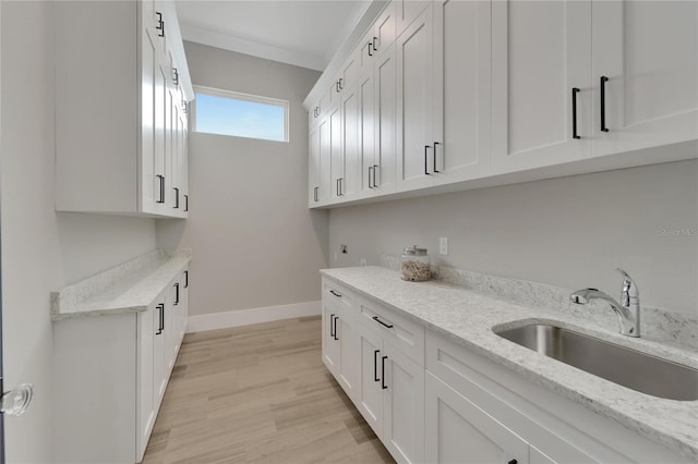 5713 Tybee Island Dr, Apollo Beach, FL 33572 - laundry area with cabinet space, light wood-style flooring, and baseboards