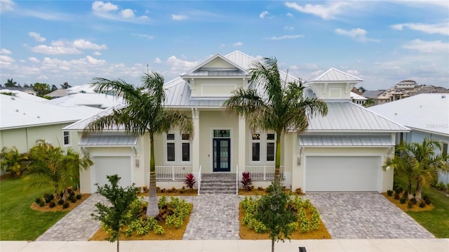 5713 Tybee Island Dr, Apollo Beach, FL 33572 - view of front of home with metal roof, decorative driveway, a porch, stucco siding, and a standing seam roof