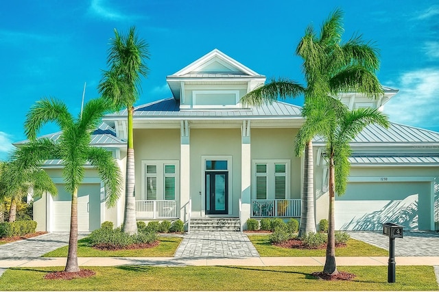 5713 Tybee Island Dr, Apollo Beach, FL 33572 - view of front of property with a porch, an attached garage, a standing seam roof, and driveway