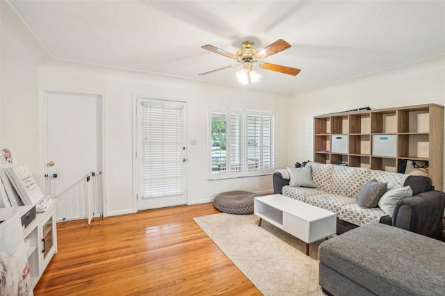 living room with ceiling fan and light hardwood / wood-style flooring