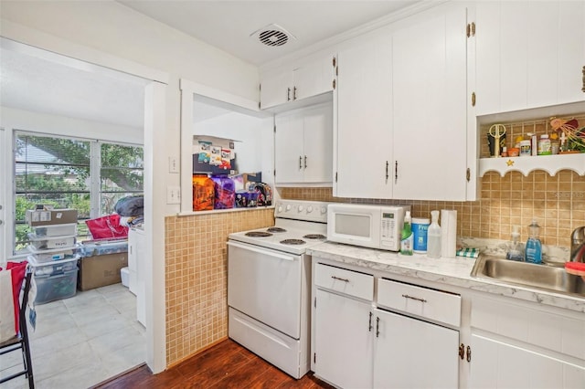 kitchen with white cabinetry, sink, white appliances, and dark wood-type flooring