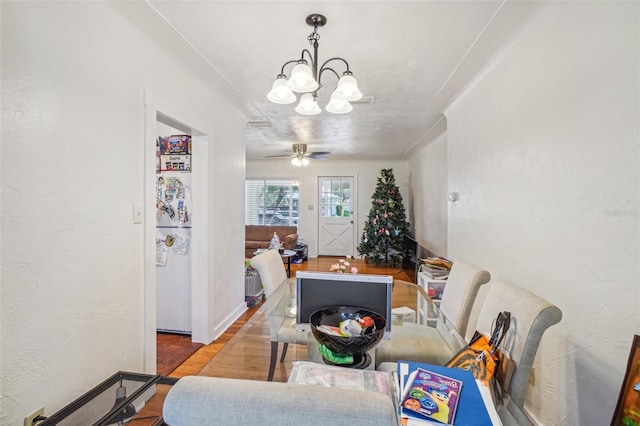 dining room featuring wood-type flooring and ceiling fan with notable chandelier