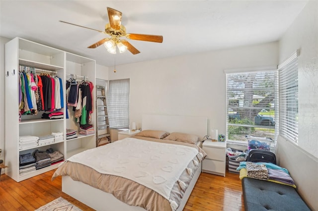 bedroom with light wood-type flooring, a closet, and ceiling fan