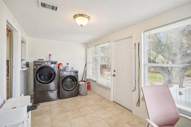 laundry room with separate washer and dryer and light tile patterned flooring