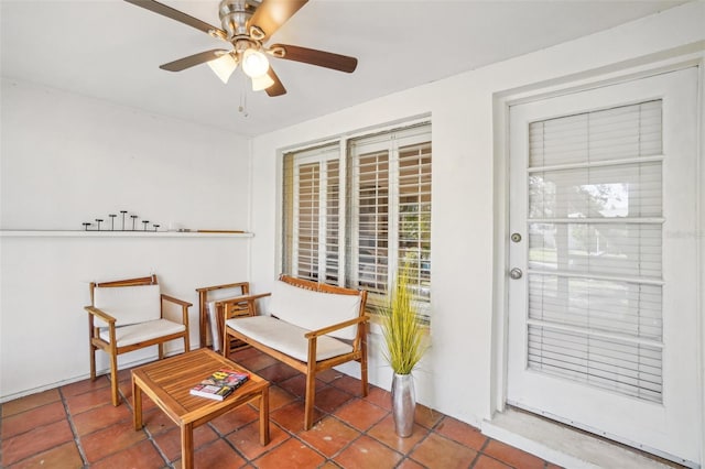 living area with tile patterned floors and ceiling fan