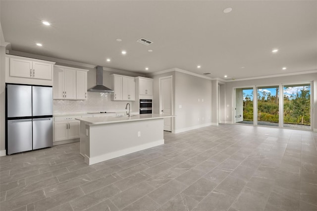 kitchen featuring white cabinets, stainless steel refrigerator, and wall chimney exhaust hood