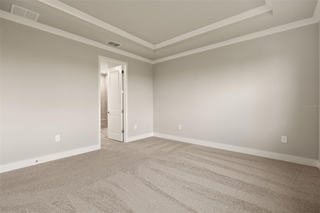 unfurnished room featuring crown molding, a tray ceiling, and carpet flooring