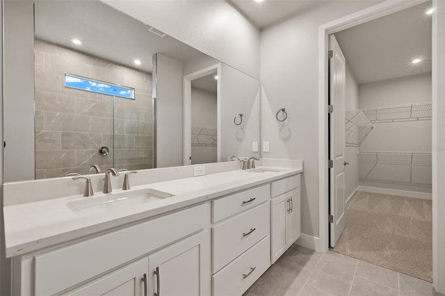 bathroom featuring vanity, tile patterned flooring, and tiled shower