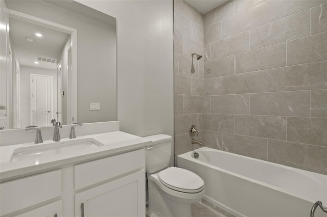 full bathroom with tiled shower / bath, vanity, and toilet