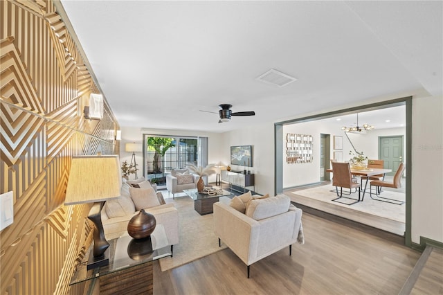 living room featuring hardwood / wood-style floors and ceiling fan with notable chandelier