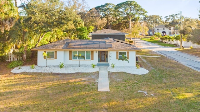 view of front of home featuring solar panels and a front yard