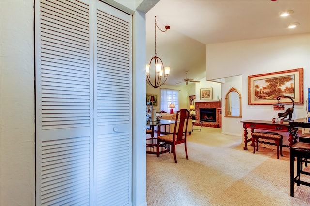 dining space with ceiling fan with notable chandelier, lofted ceiling, and light carpet