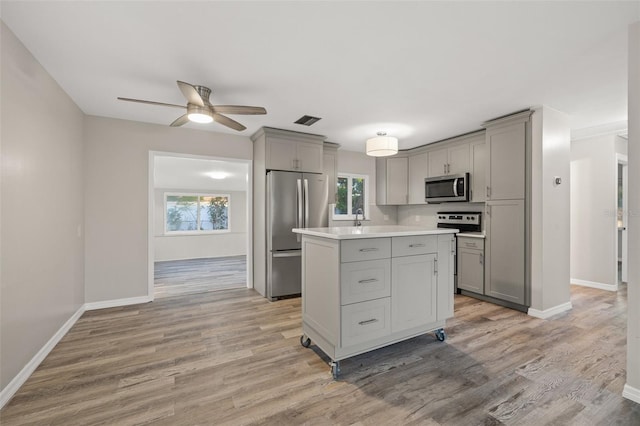 kitchen featuring gray cabinetry, ceiling fan, light hardwood / wood-style flooring, and stainless steel appliances