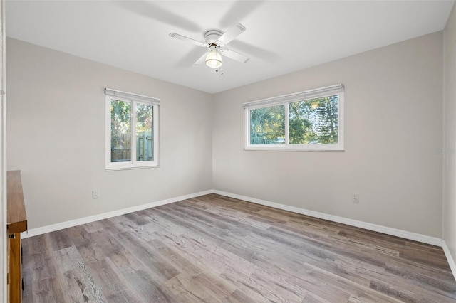 spare room with ceiling fan, a healthy amount of sunlight, and light hardwood / wood-style floors