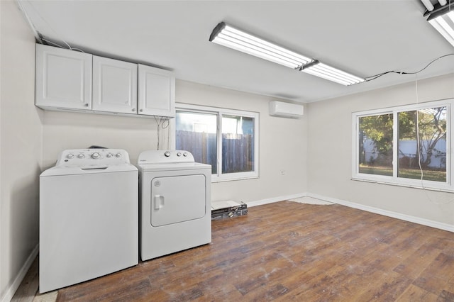 laundry area with cabinets, dark hardwood / wood-style flooring, a healthy amount of sunlight, and washing machine and clothes dryer