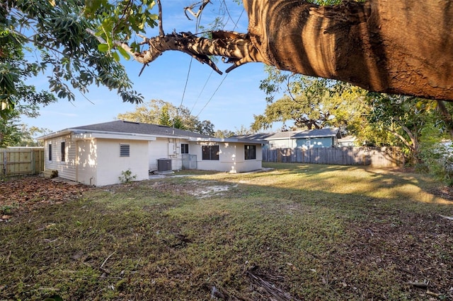 back of house featuring a lawn and central AC unit