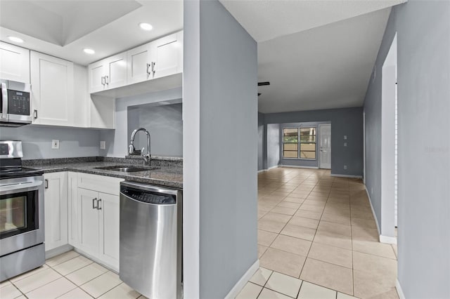 3034 Eastland Blvd Unit D108, Clearwater, FL 33761 - kitchen featuring appliances with stainless steel finishes, light tile patterned floors, white cabinetry, dark stone counters, and recessed lighting