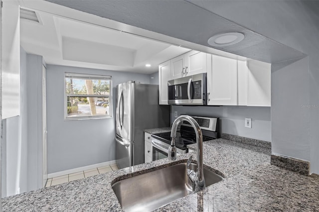 3034 Eastland Blvd Unit D108, Clearwater, FL 33761 - kitchen with stainless steel appliances, a raised ceiling, white cabinetry, stone countertops, and tile patterned floors