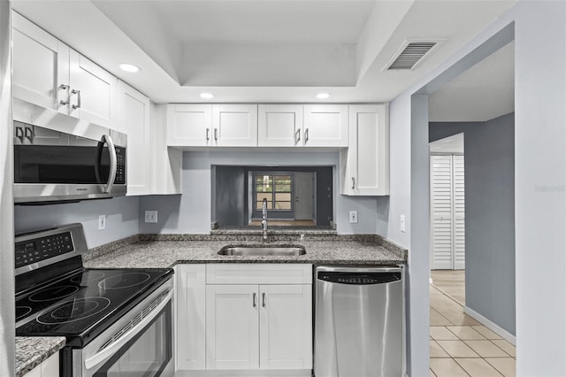 3034 Eastland Blvd Unit D108, Clearwater, FL 33761 - kitchen with stainless steel appliances, white cabinetry, stone countertops, light tile patterned flooring, and recessed lighting
