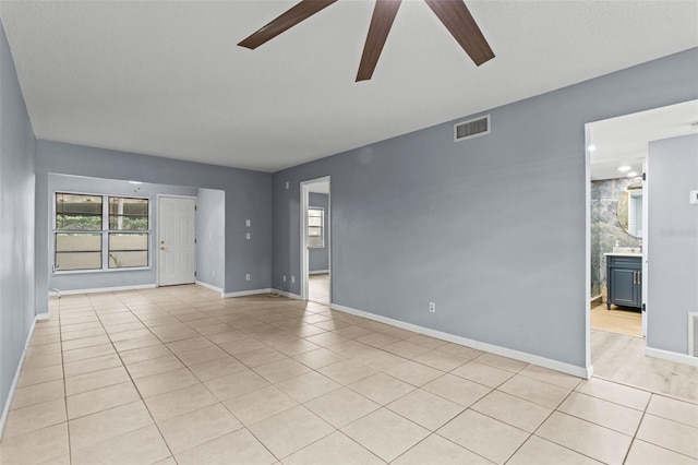 tiled spare room with ceiling fan