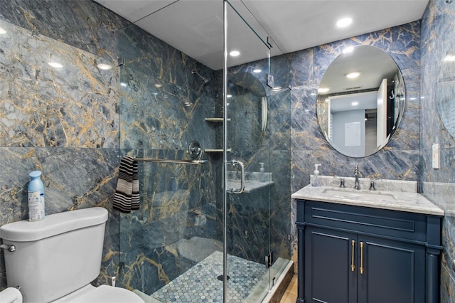 bathroom featuring an enclosed shower, vanity, toilet, and tile walls