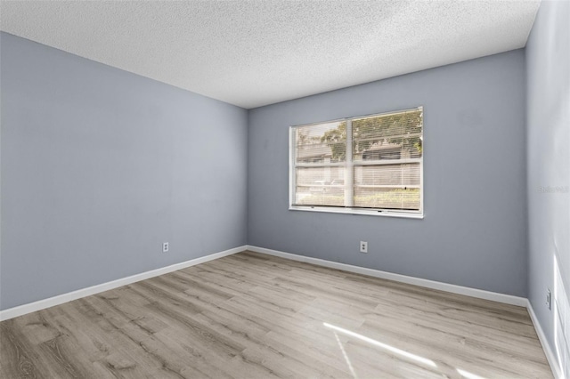 empty room featuring a textured ceiling and light wood-type flooring