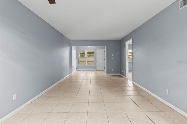 empty room with ceiling fan and light tile patterned flooring