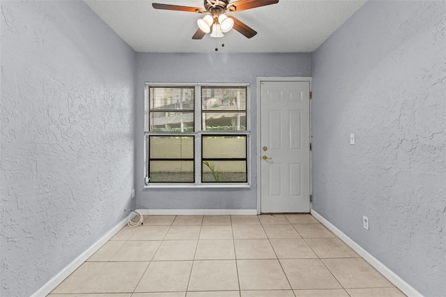 tiled spare room with ceiling fan and a textured ceiling