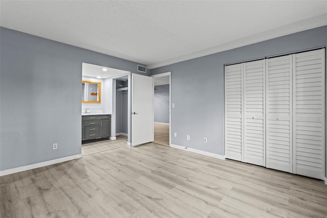 3034 Eastland Blvd Unit D108, Clearwater, FL 33761 - unfurnished bedroom with light wood-style floors, ensuite bath, two closets, recessed lighting, and bar