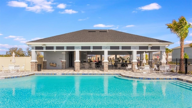 view of swimming pool featuring a patio area and exterior kitchen