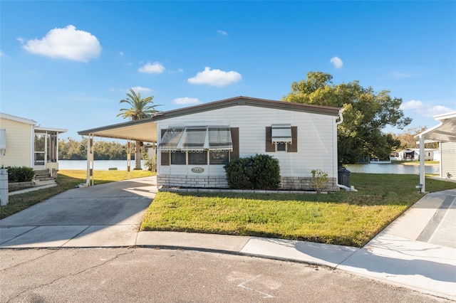 view of front of property featuring a water view, a front yard, and a carport