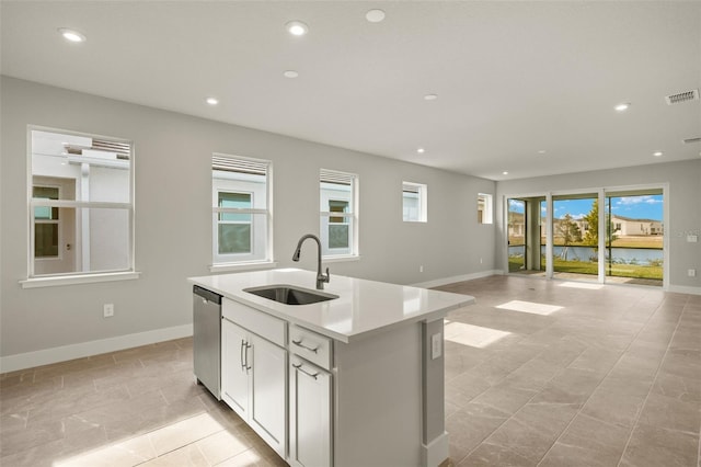 kitchen featuring sink, white cabinets, dishwasher, and a center island with sink