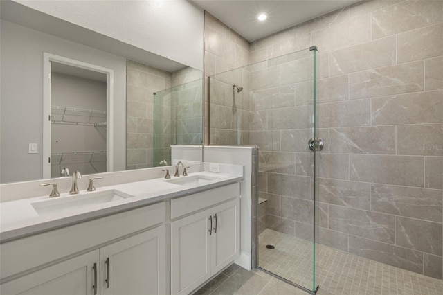 bathroom featuring tiled shower, vanity, and tile patterned flooring