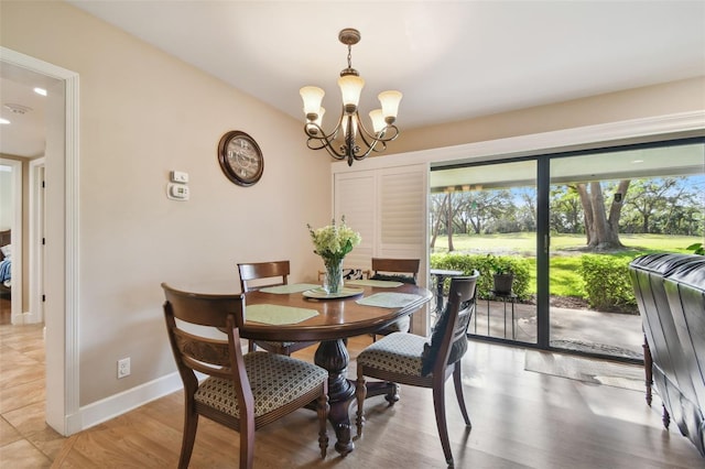 dining space featuring hardwood / wood-style flooring and a notable chandelier