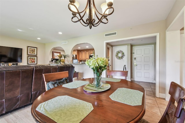 tiled dining area featuring an inviting chandelier