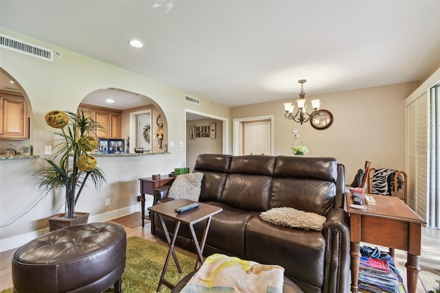 living room with a chandelier and light hardwood / wood-style flooring