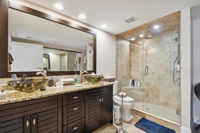 bathroom with tile patterned flooring, vanity, a shower with shower door, and toilet