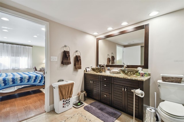 bathroom featuring wood-type flooring, vanity, and toilet