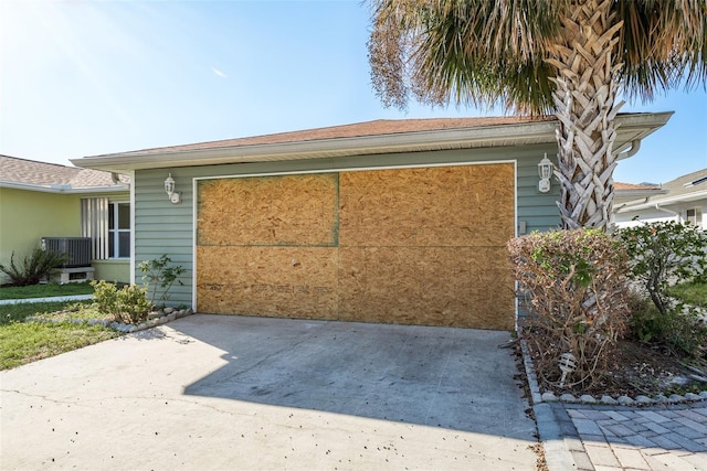 view of side of property with cooling unit and a garage