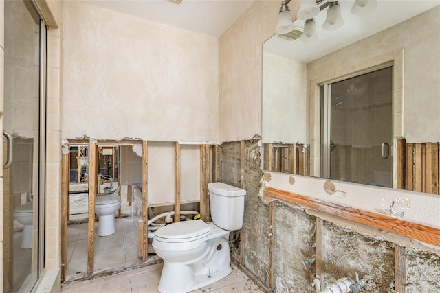 bathroom featuring toilet and a shower with door