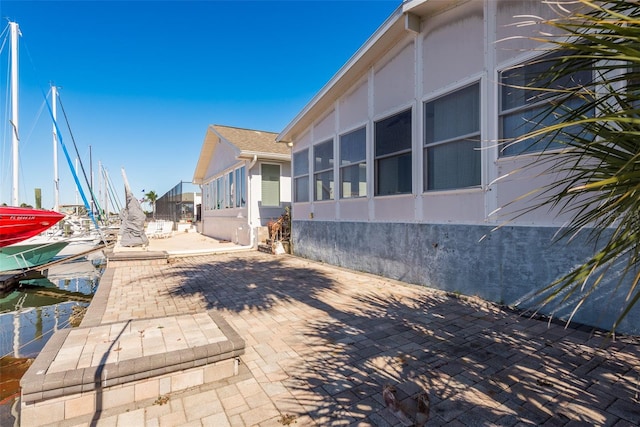 view of property exterior featuring a patio area and a sunroom