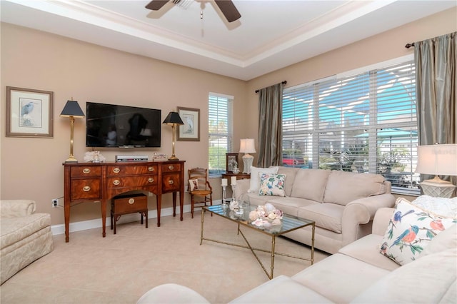 tiled living room featuring ceiling fan and a tray ceiling