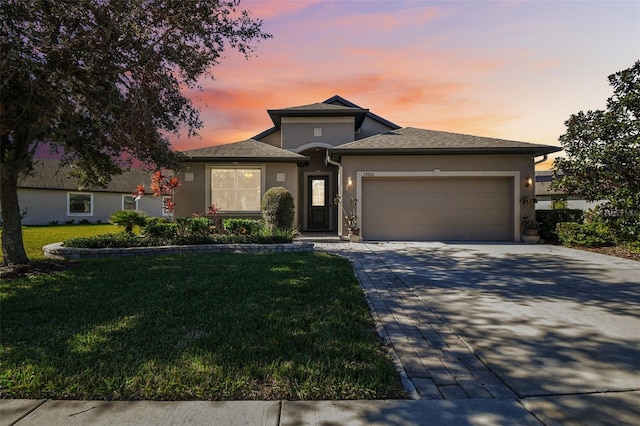 prairie-style house featuring a garage and a yard