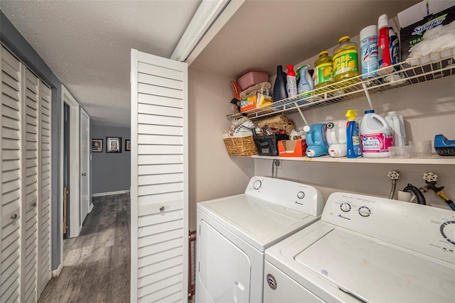 laundry room featuring washer and dryer, a textured ceiling, and dark hardwood / wood-style floors