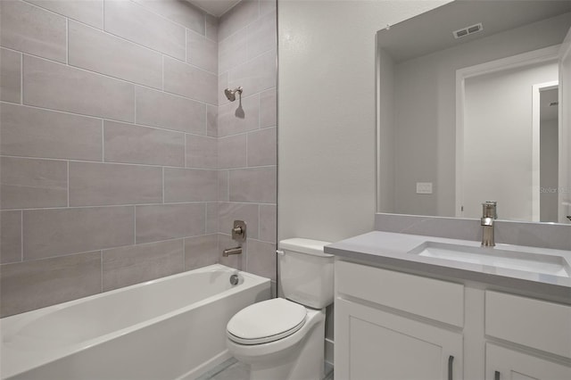 full bathroom featuring vanity, tiled shower / bath, and toilet