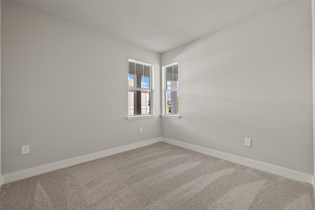 carpeted empty room with a textured ceiling