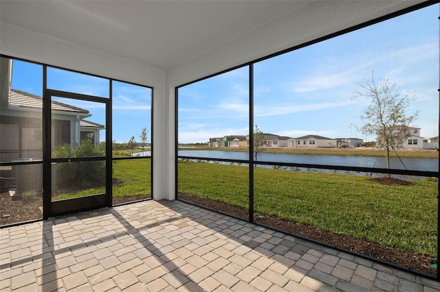 unfurnished sunroom featuring a water view